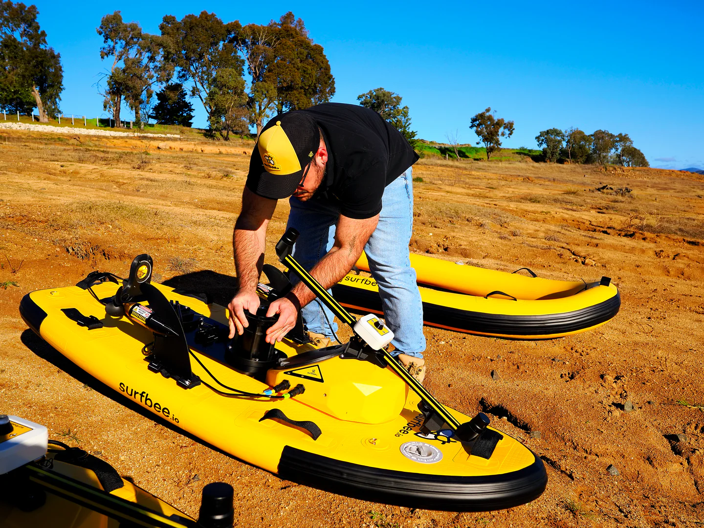 A field technician fitting an instrument to a Surfbee vessel at Lake Hume