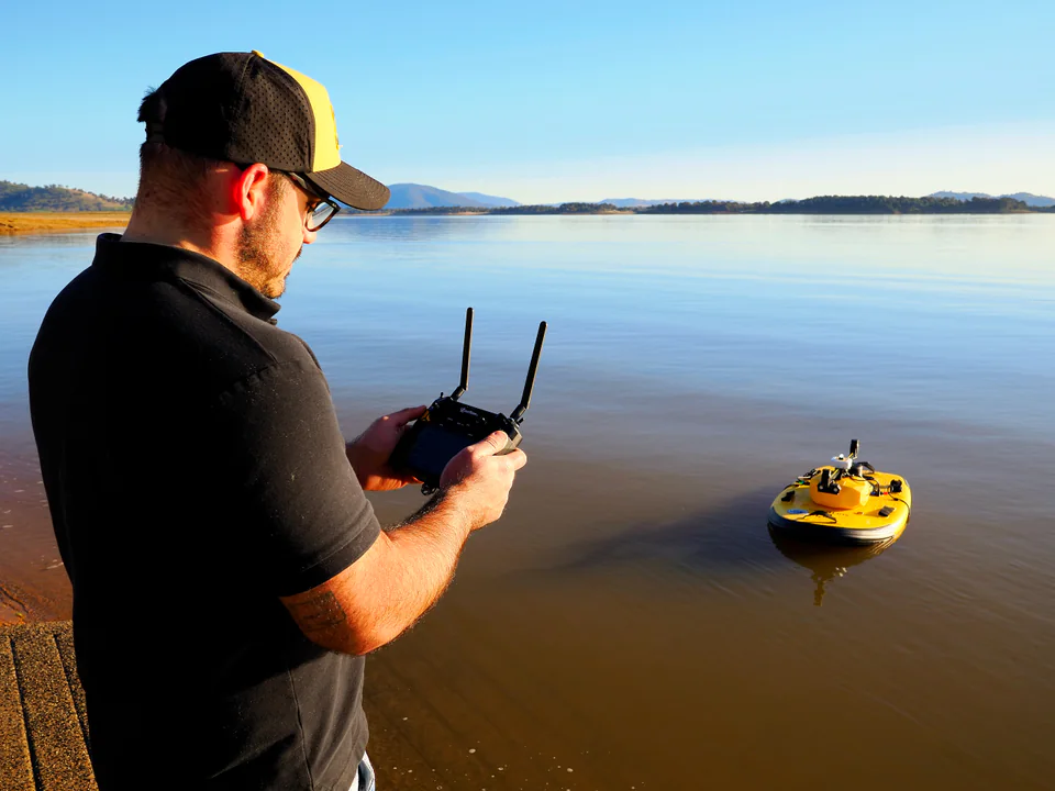 An operator controlling a Surfbee vessel from the shoreline