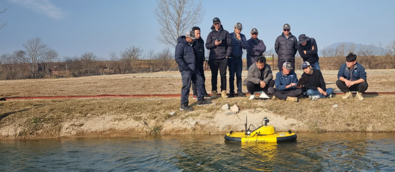 Field team monitoring a Surfbee vessel during a streamflow measurement