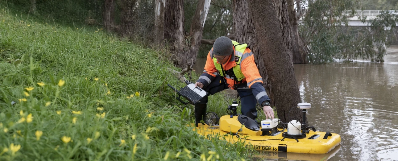 WaterNSW operator configuring a Surfbee vessel beside a waterway